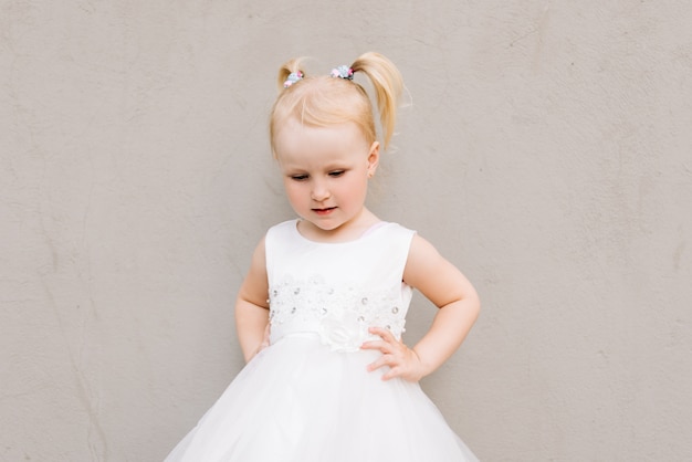 Menina feliz num vestido branco em cinza