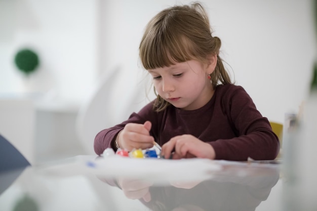 menina feliz pintando na imagem da tela em casa