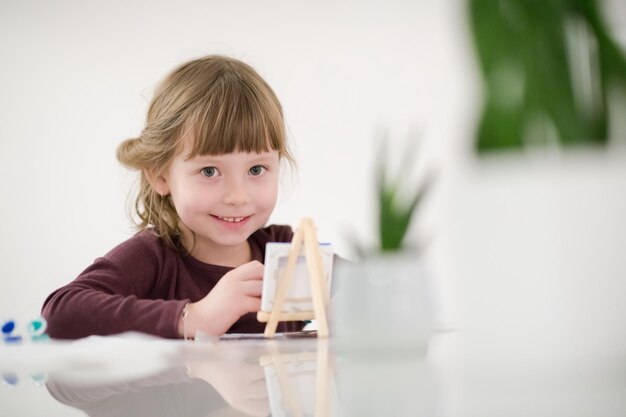 menina feliz pintando na imagem da tela em casa