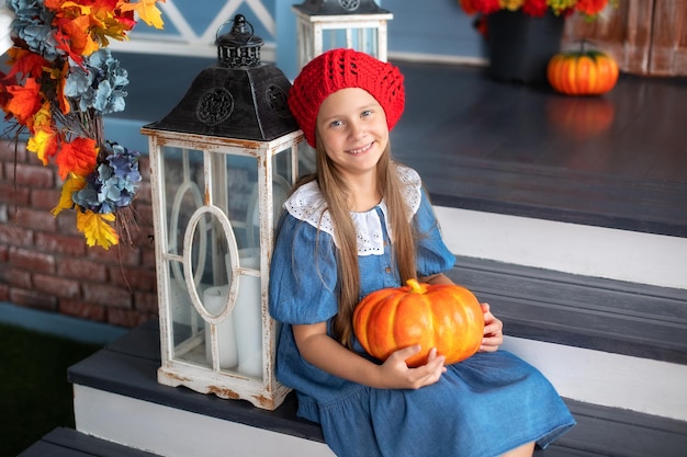 Menina feliz segurando abóbora no Halloween