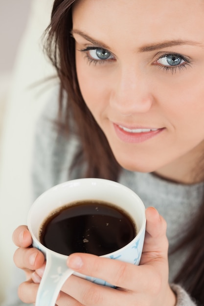 Menina feliz segurando uma xícara de café