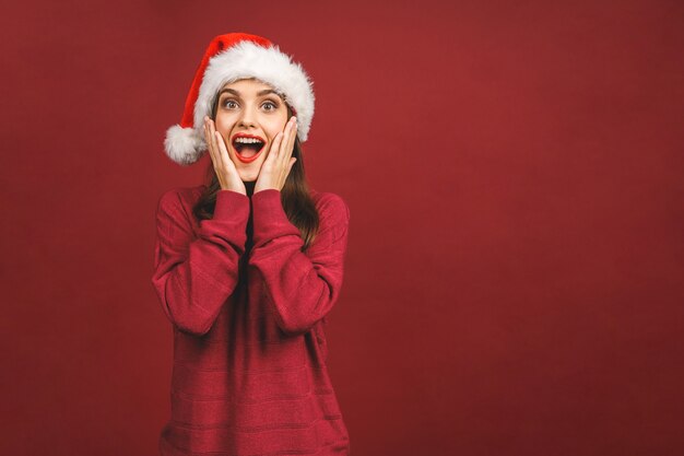 Menina feliz sorridente com chapéu de papai noel