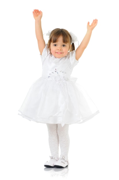 Menina feliz sorrindo e posando com vestido e sapatos brancos, mãos abertas, luz de fundo para uma foto de corpo inteiro