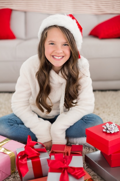 Menina festiva sorrindo para a câmera com presentes