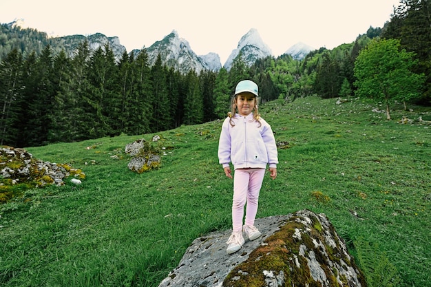 Menina fica em pedra nas montanhas Vorderer Gosausee Gosau Upper Austria