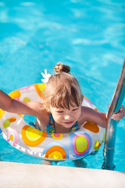 Menina fora da piscina na escada