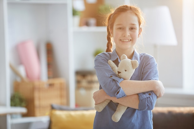 Menina gengibre, abraçando, urso