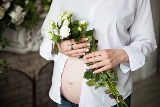 Menina grávida, com lindas rosas brancas, esperando bebê, 9 meses, família