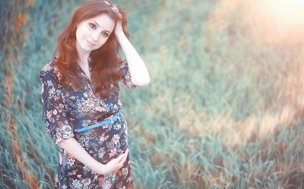 Menina grávida com um vestido na natureza em uma caminhada