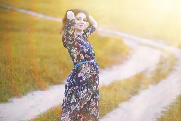 Menina grávida com um vestido na natureza em uma caminhada