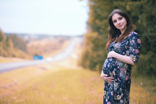 Menina grávida em um vestido na natureza