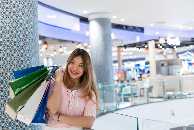 Menina hippie asiática fazendo compras na loja de departamentosMulher feliz com sacolas de compras na mão no shopping pessoas da tailândiaAs senhoras gostam de comprar o melhor