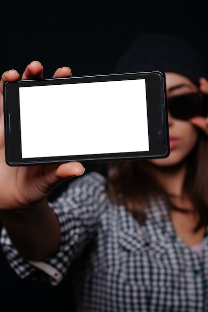 Menina hippie segurando um smartphone com uma tela em branco