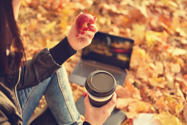 Menina hipster com xícara de café e maçã