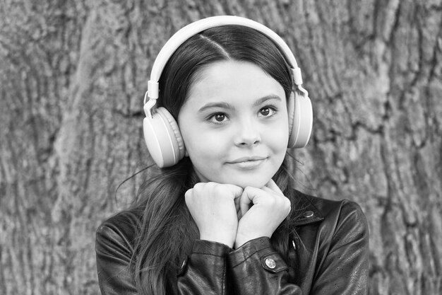 Menina hipster ouvindo música fones de ouvido modernos fundo da natureza conceito de música favorita