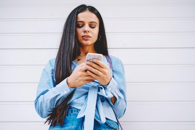 Menina hipster pensativa lendo mensagem de renda no celular recebendo más notícias de uma jovem triste amiga