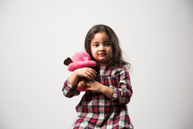 Menina indiana asiática brincando com um brinquedo macio de pelúcia