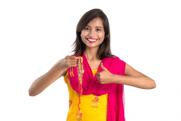 Menina indiana bonita que mostra Rakhis por ocasião de Raksha bandhan. A irmã amarra Rakhi como símbolo de intenso amor por seu irmão.