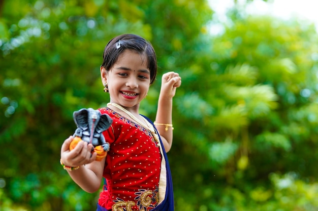 Menina indiana bonitinha celebrando o festival lord ganesha