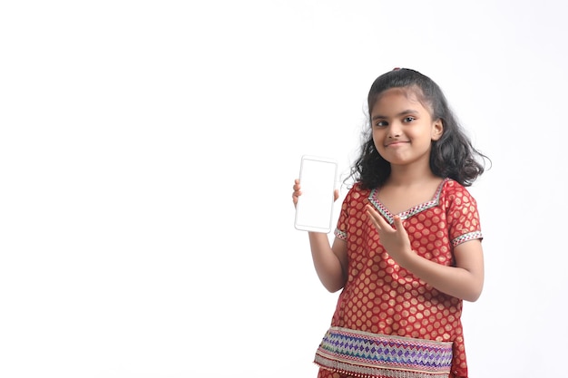 Menina indiana bonitinha mostrando smartphone em fundo branco