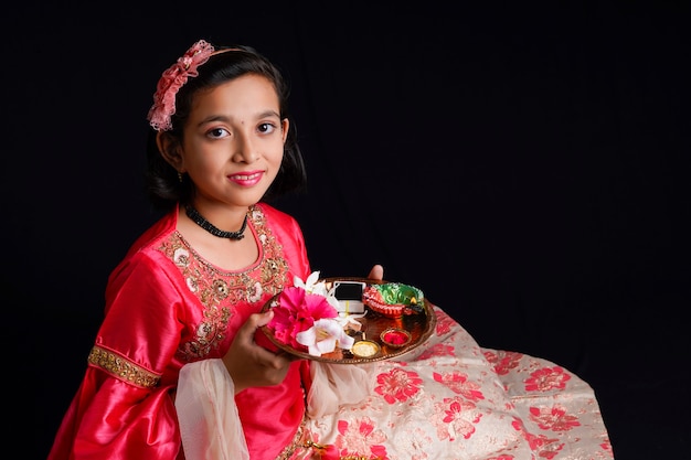 Menina indiana bonitinha segurando diya ou lâmpadas de óleo para a celebração de Diwali.