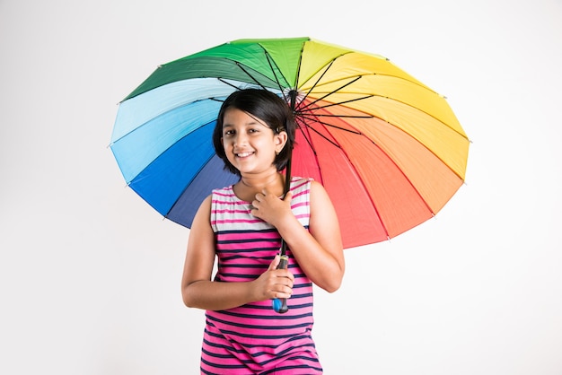 Menina indiana com guarda-chuva multicolorido, isolada sobre o branco