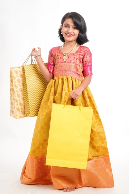 Menina indiana feliz segurando sacolas de compras no fundo branco