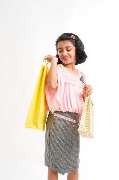 Menina indiana feliz segurando sacolas de compras no fundo branco