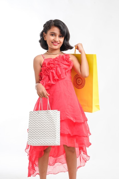 Menina indiana feliz segurando sacolas de compras no fundo branco