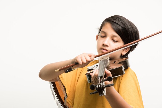 Menina indiana ou asiática bonitinha tocando violino, isolada sobre fundo branco