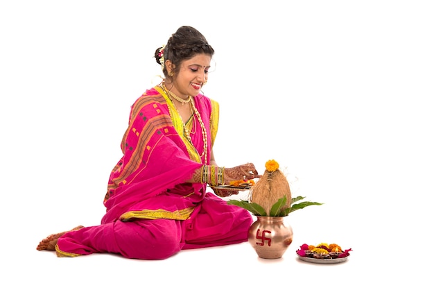 Menina indiana tradicional em adoração com kalash de cobre