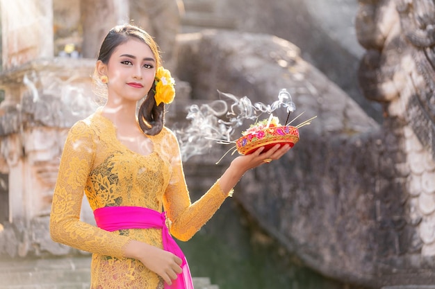 Foto menina indonésia com dança tradicional à fantasia no templo de bali, indonésia