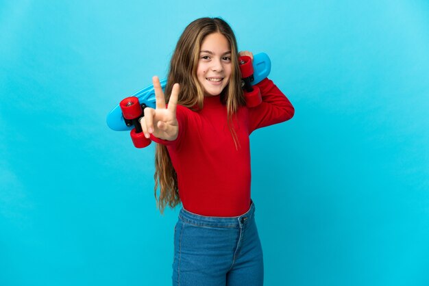 Menina isolada azul com um patim fazendo gesto de vitória