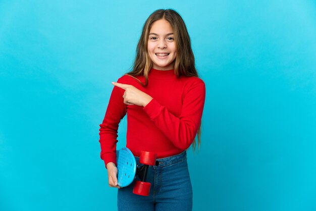 Menina isolada em azul com um patim apontando para o lado