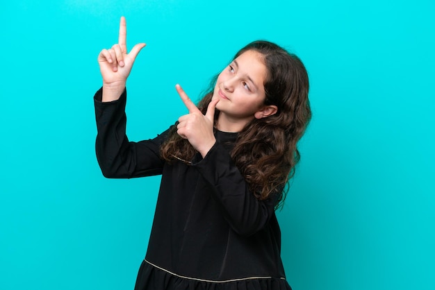 Foto menina isolada em fundo azul apontando com o dedo indicador uma ótima ideia