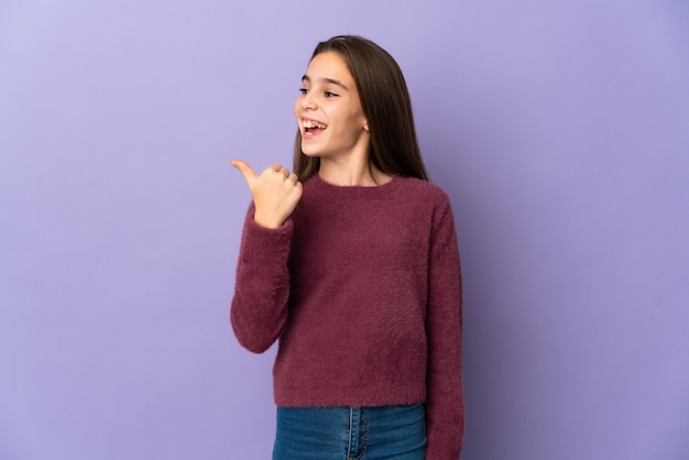 Menina isolada em um fundo roxo com a intenção de descobrir a solução enquanto levanta um dedo