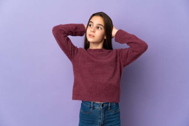 Menina isolada em um fundo roxo frustrada e cobrindo as orelhas