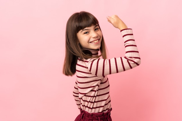Foto menina isolada na parede rosa fazendo um gesto forte