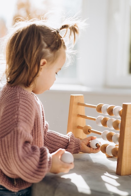 Menina joga brinquedos na sala de estar Brinquedo de madeira Montessori pirâmide dobrada Círculo triângulo retângulo elementos de madeira de brinquedos infantis brinquedo colorido azul amarelo vermelho verde