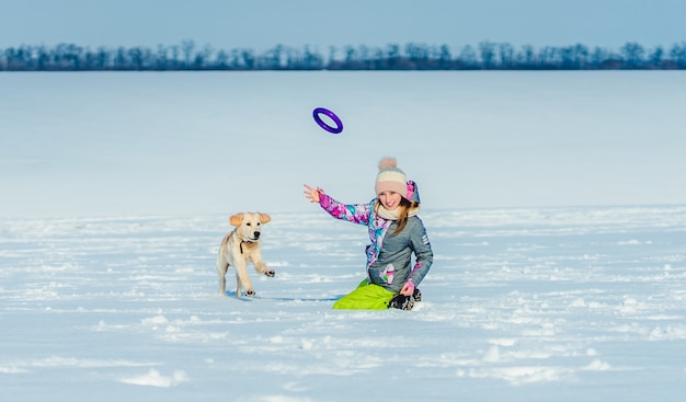 Menina jogando anel para cachorro