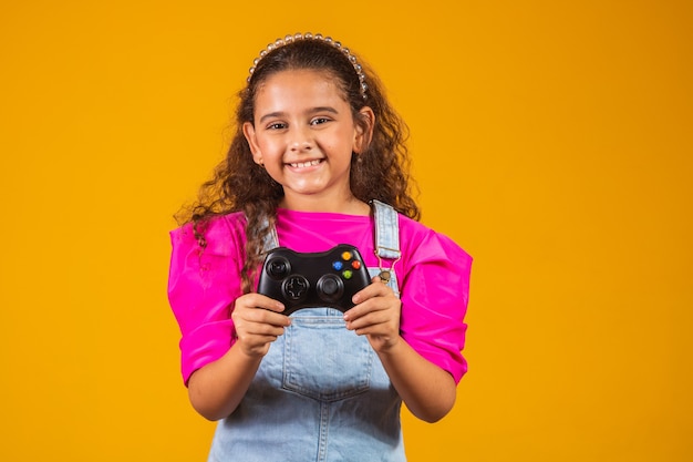 Menina jogando videogame em fundo amarelo.