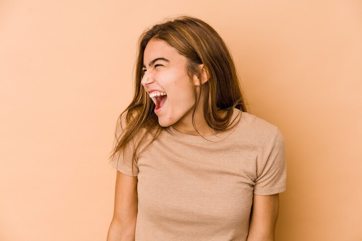 Foto menina jovem adolescente magrela caucasiana gritando com muita raiva, conceito de raiva, frustrada.