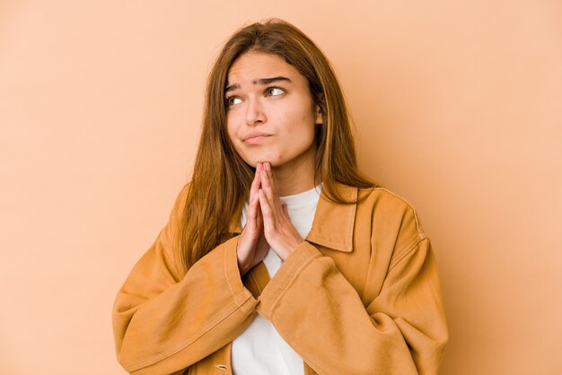 Menina jovem adolescente magrela caucasiana rezando, mostrando devoção, pessoa religiosa em busca de inspiração divina.