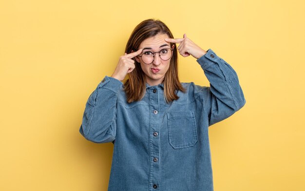 Menina jovem bonita com um olhar sério e concentrado, fazendo um brainstorming e pensando sobre um problema desafiador