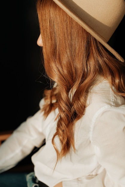 Menina jovem com cabelo ruivo e um chapéu grande close-up