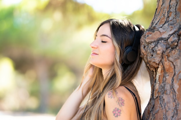 Menina jovem, em, ao ar livre, em, um, parque, escutar música