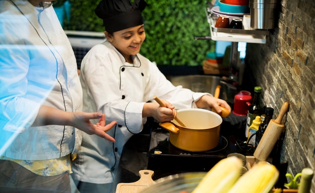 Menina jovem, em, cozinheiro uniforme, aprendizagem, culinário