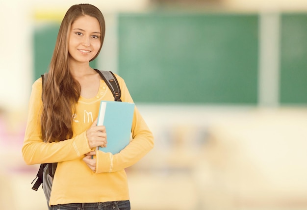 Menina jovem estudante com livro no fundo