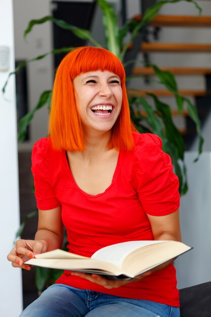 Menina jovem, lendo um livro, casa