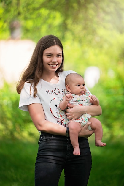 Menina jovem, segurando, um, bebê recém-nascido